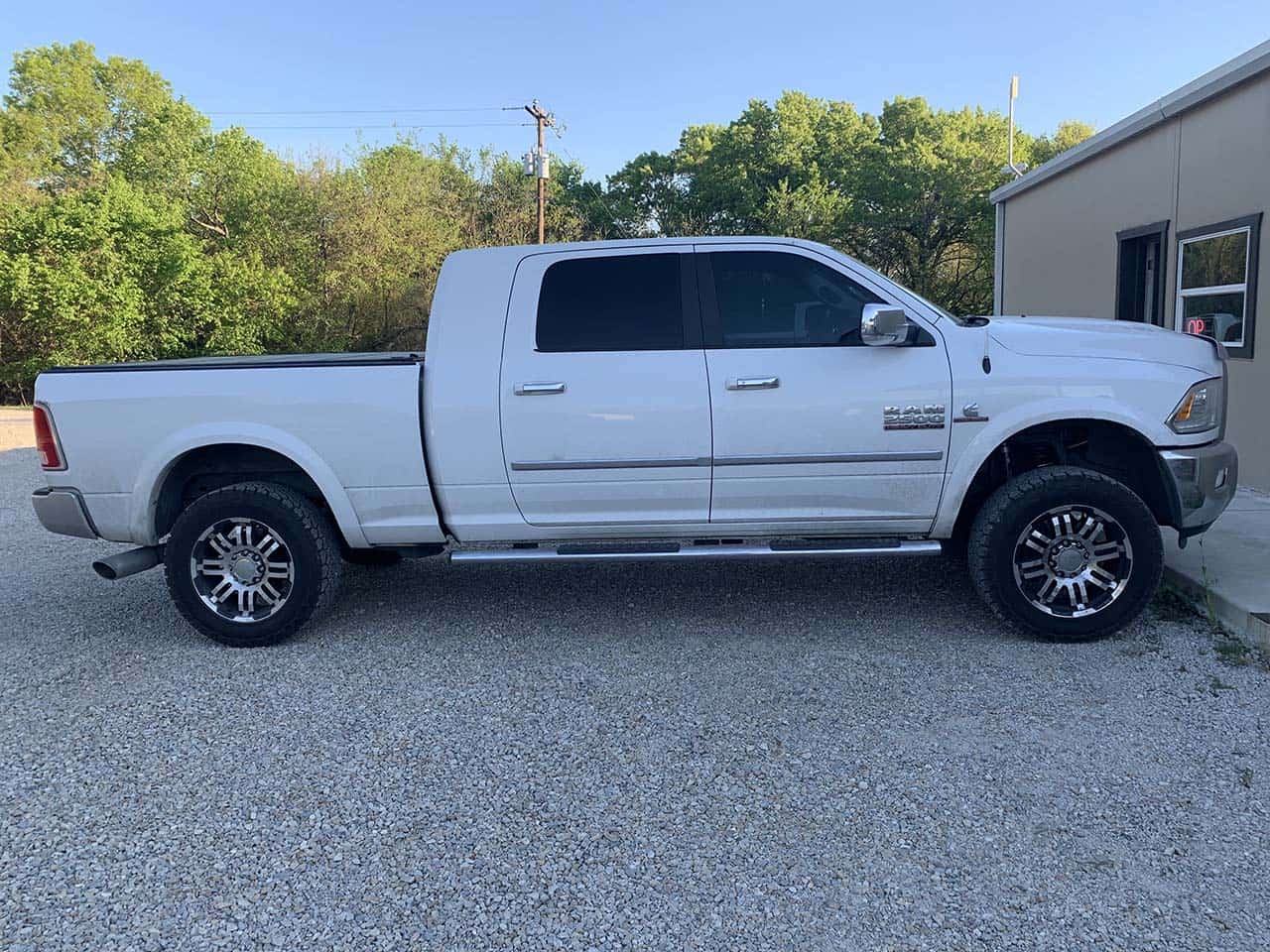 Side view of white Ram 2500 truck with Cummins badge.